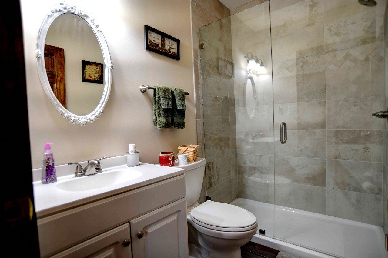 A bathroom with a toilet , sink , and shower.