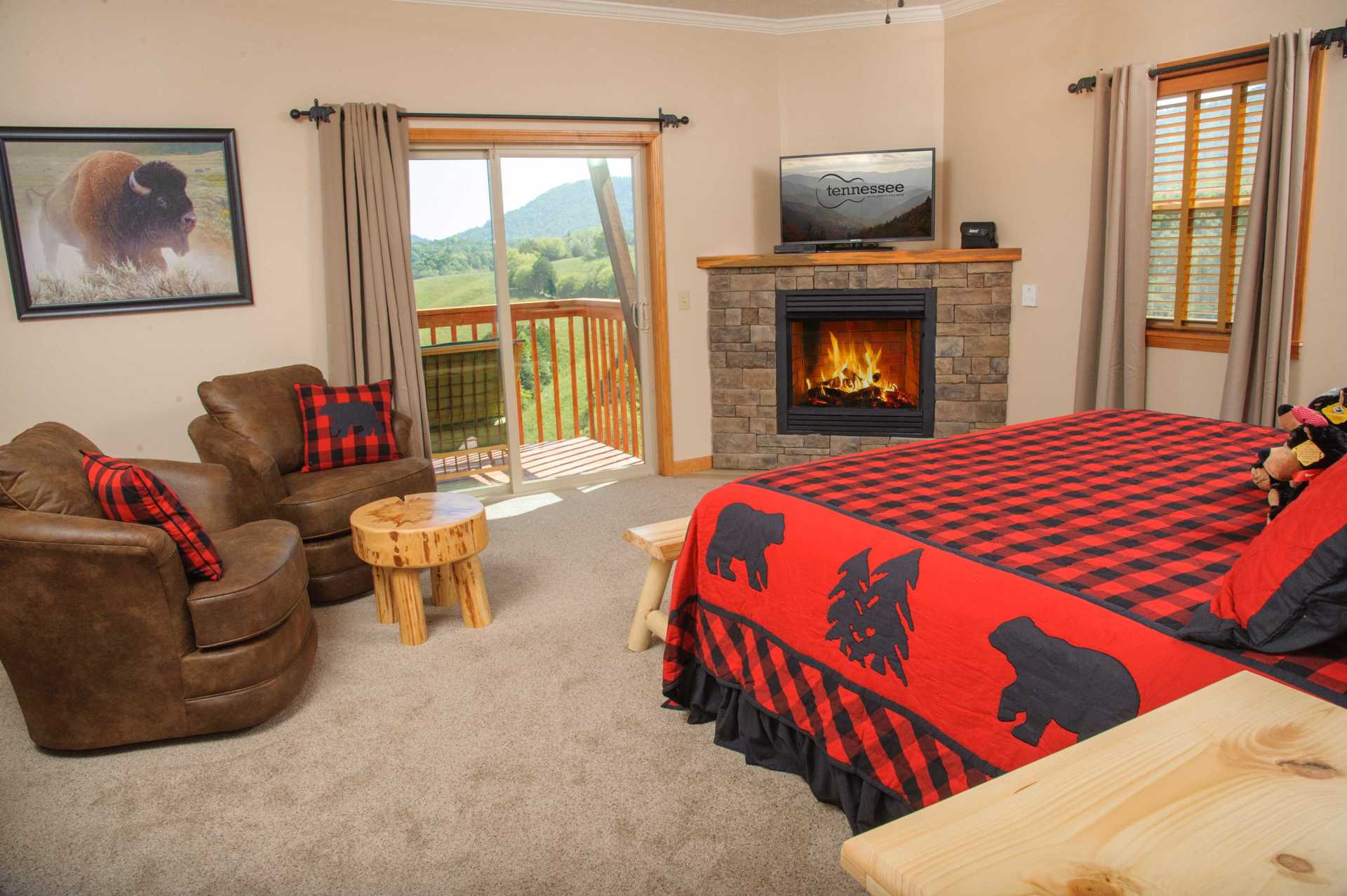 A bedroom with a bed , chairs , and a fireplace.