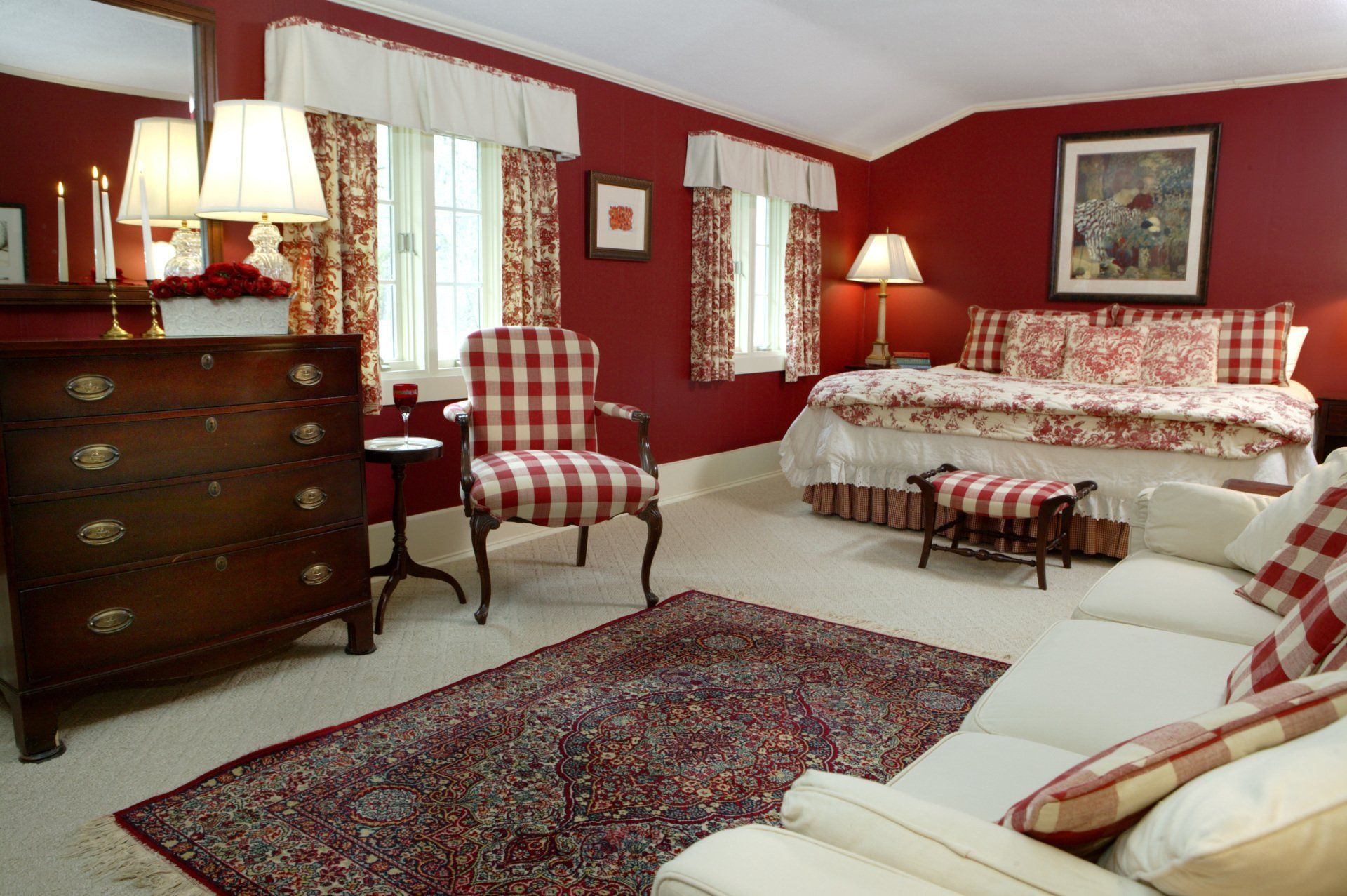 A bedroom with red walls and white furniture