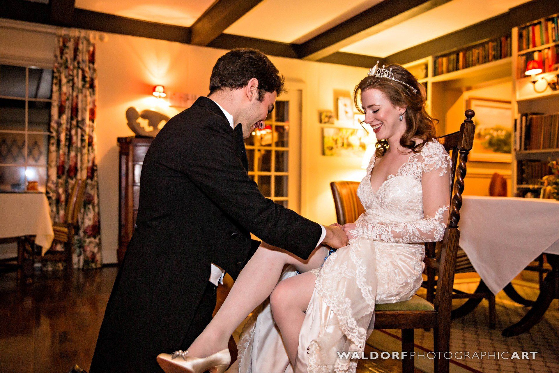 A bride and groom are posing for a picture in a living room