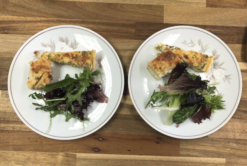 Two plates of food are sitting on a wooden table.