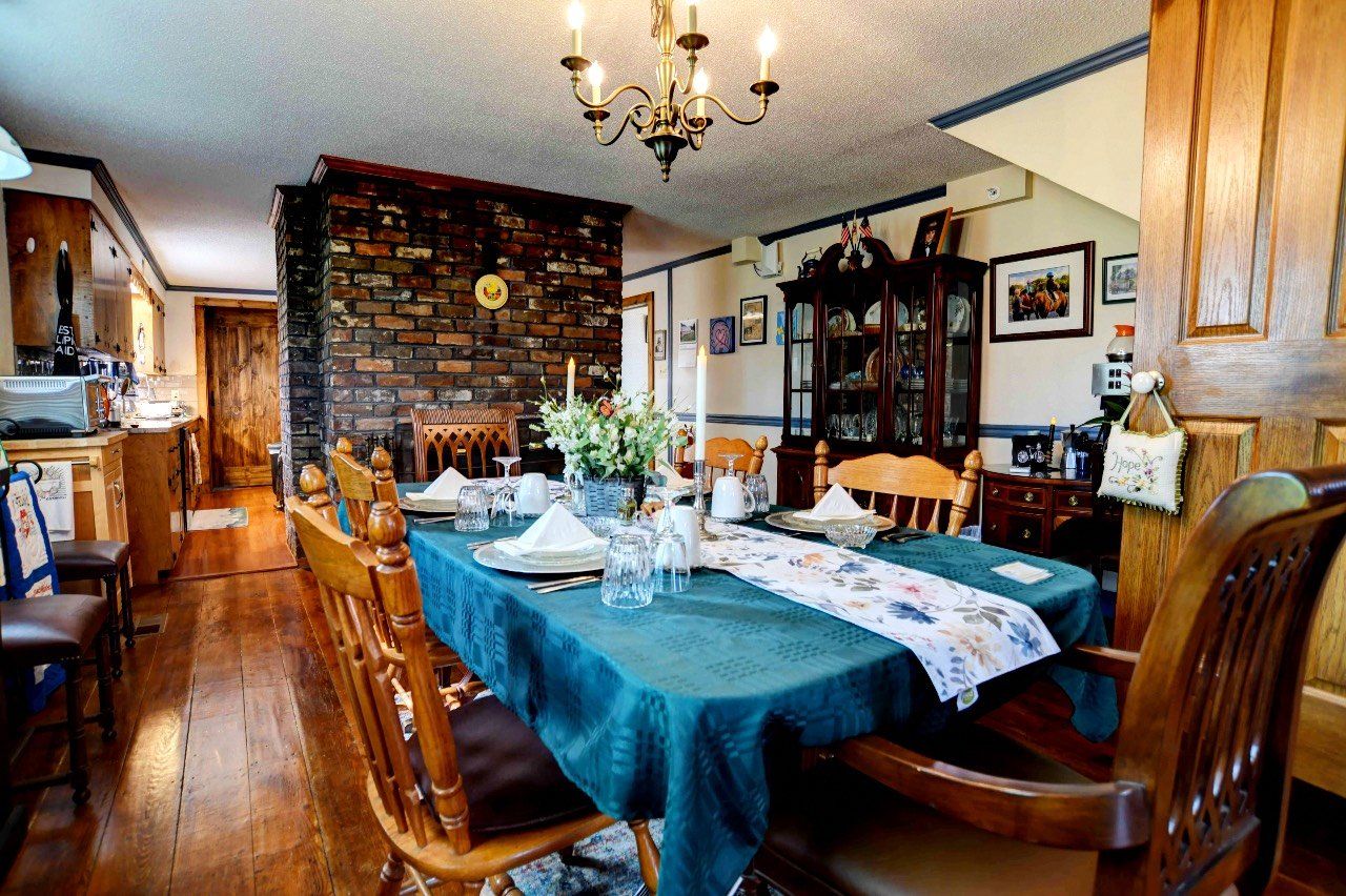 A dining room with a table and chairs and a chandelier