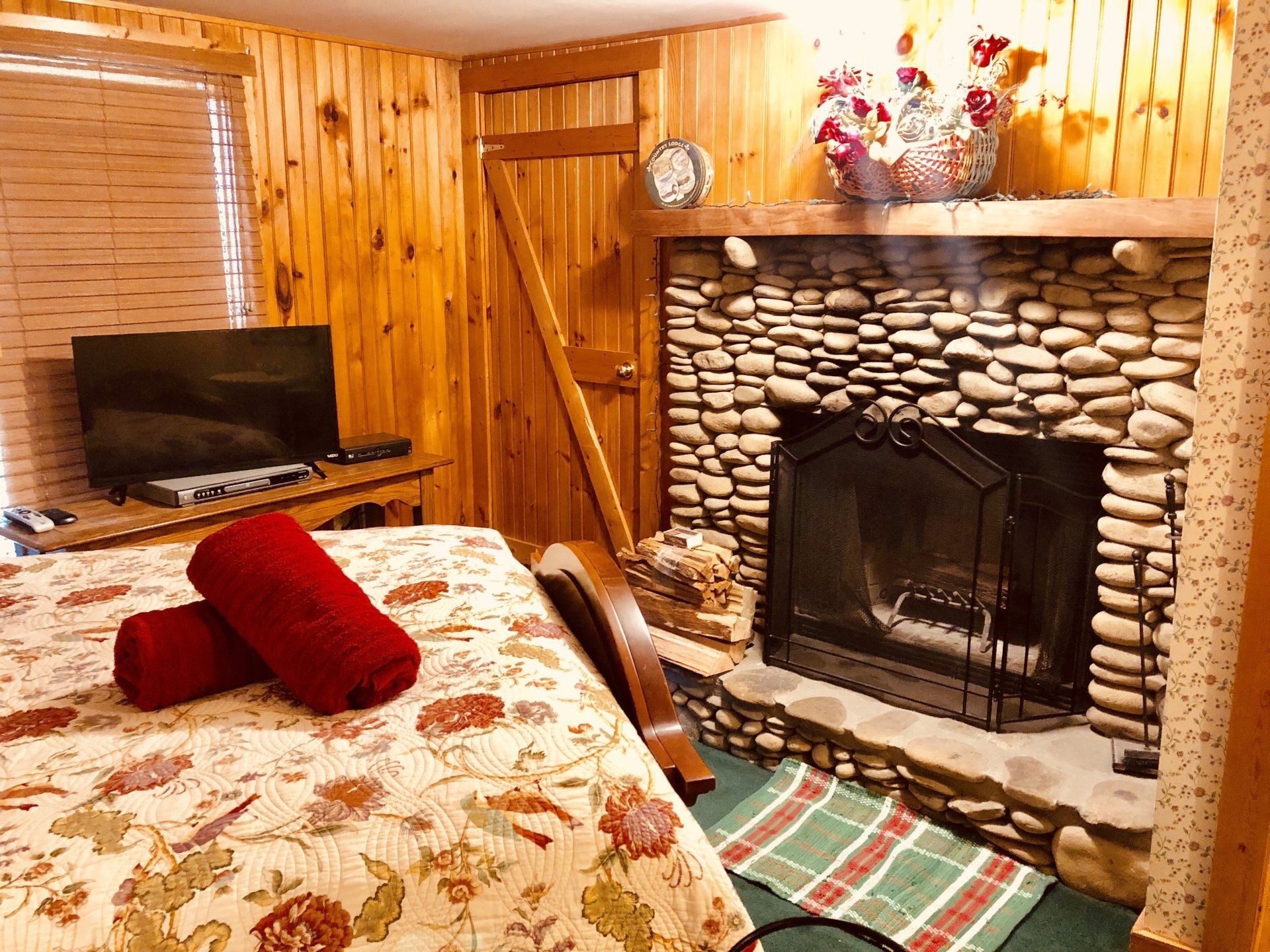 A bedroom with a bed , television , and fireplace.