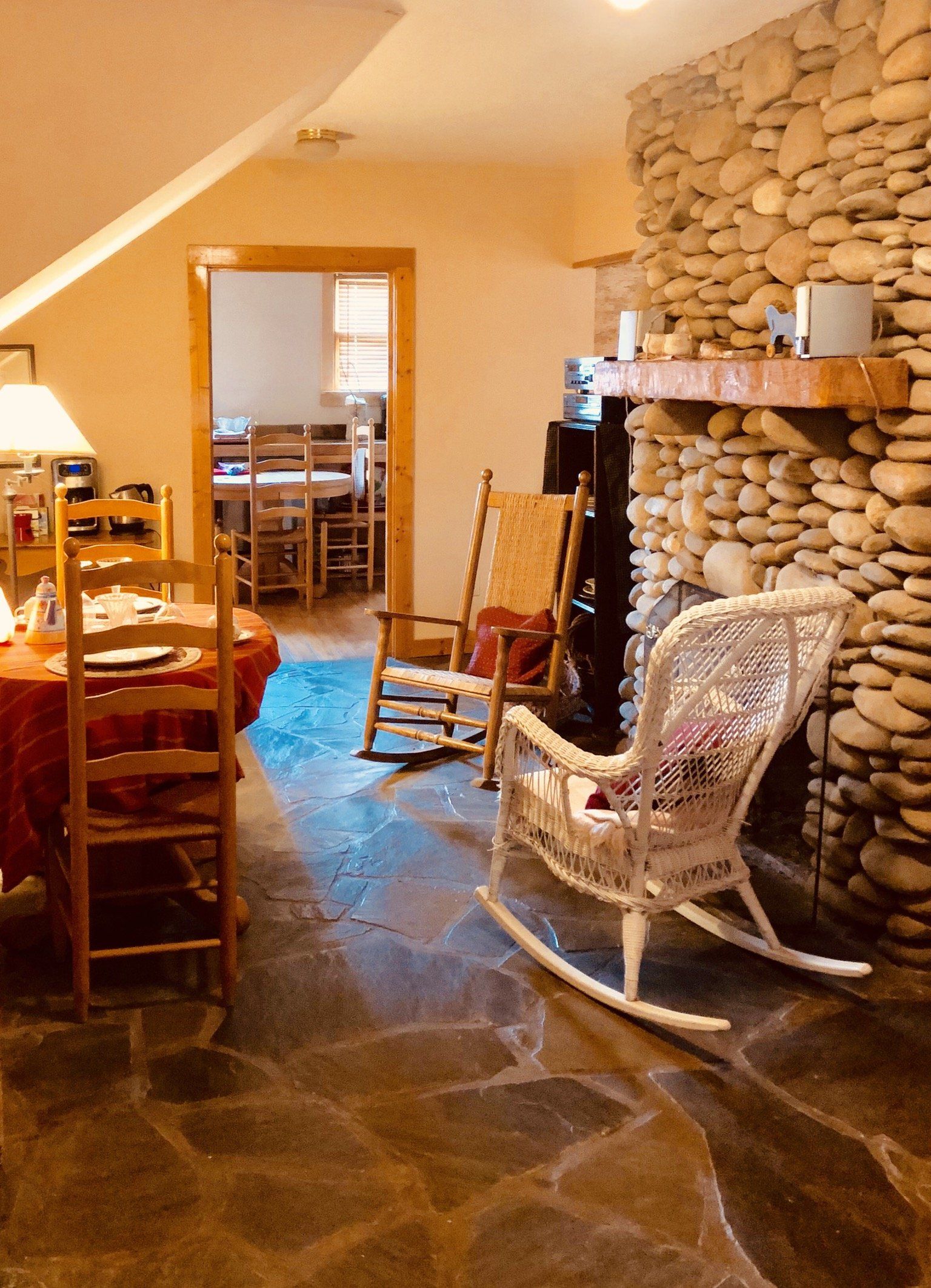 A living room with rocking chairs and a stone fireplace