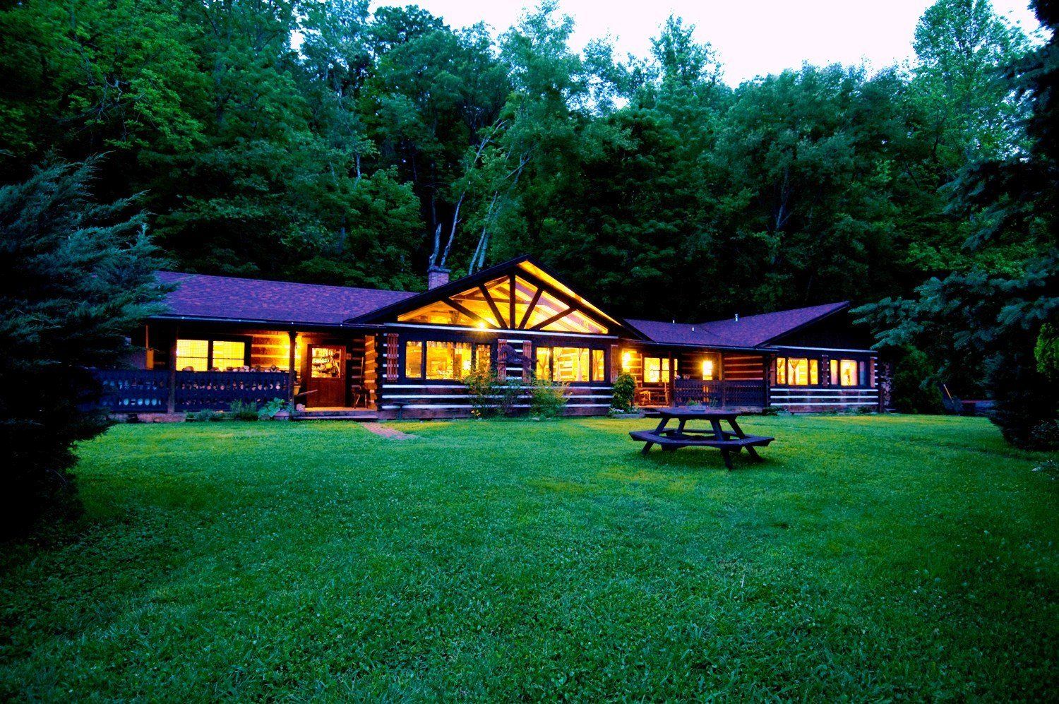 A log cabin with a picnic table in front of it