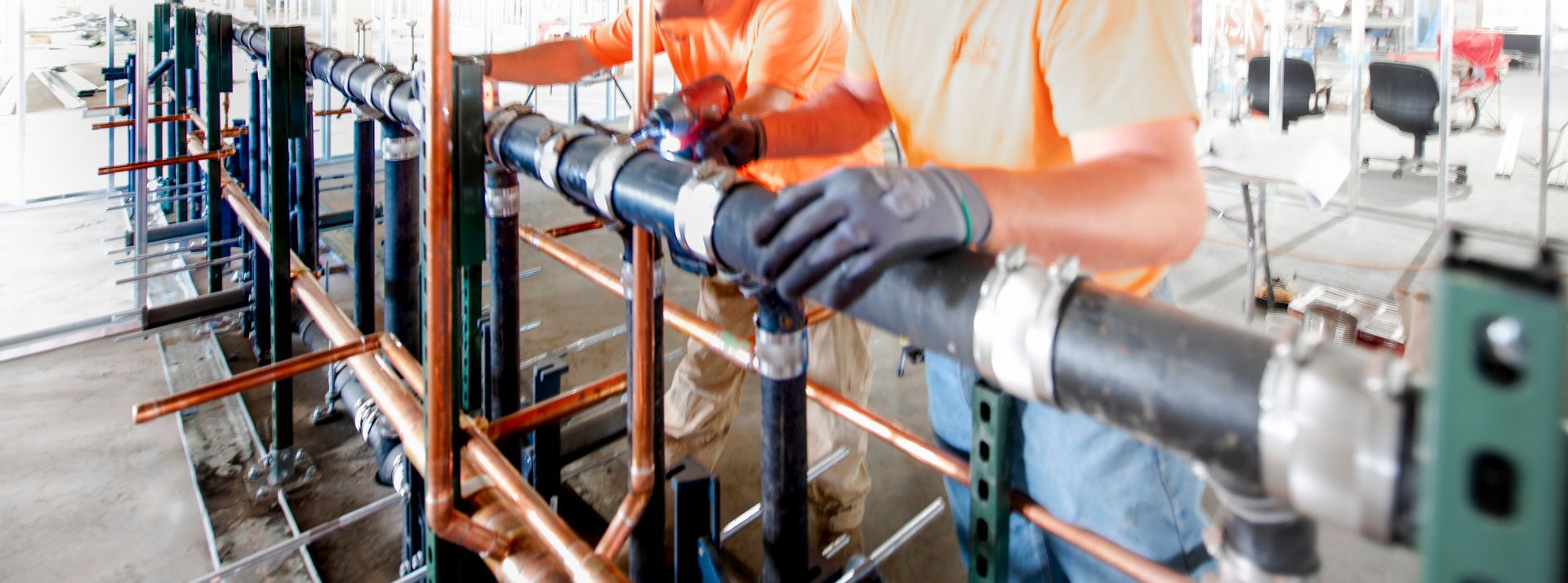 Commercial plumbing contractors installing new pipes in a commercial building.