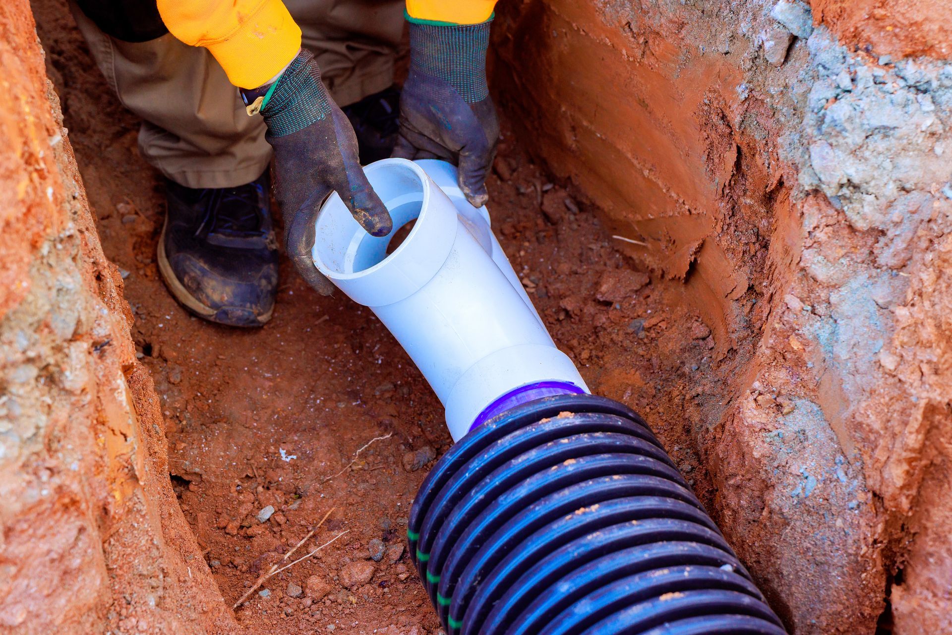 Commercial plumbing contractors installing drainage pipes.