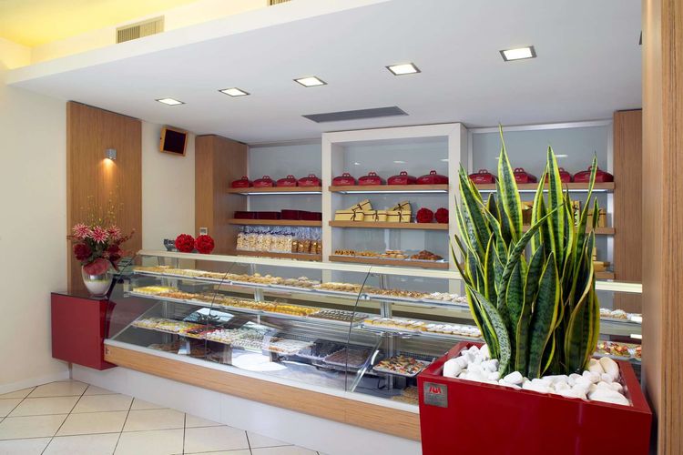 La Pasticceria Maresi è una grande realtà molto conosciuta a Brescia. Situata a fianco del principale mercato ortofrutticolo è il sinonimo di grande qualità e produzione grazie al laboratorio annesso al punto vendita diretto. Colore rosso rubino  e legno teak verniciato si uniscono per dare risalto alla grande esposizione dei prodotti delle vetrine canalizzate e continue dove la qualità che offre Maresi si ritrova esposta in forme e profumi dell’arte pasticcera.