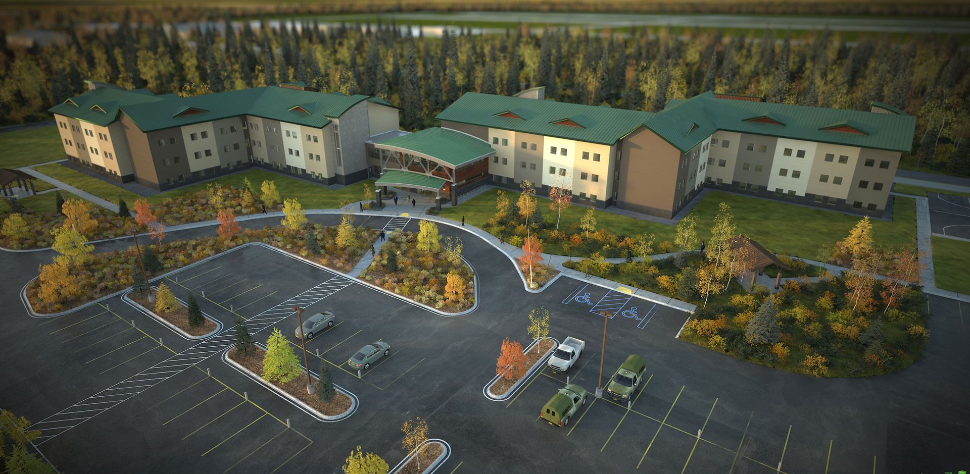 Aerial view of a large complex with green roofs and beige walls surrounded by a parking lot and forest.
