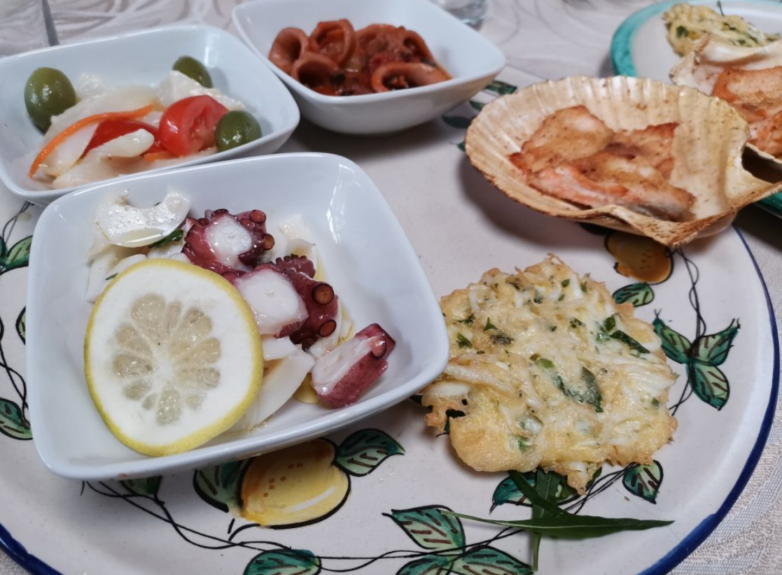 Piatto di antipasti di mare con polpo, fritture e altri piatti.