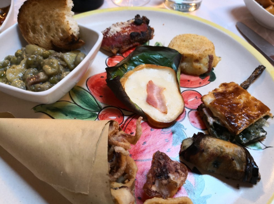 Un piatto di antipasti italiani assortiti, tra cui fritture e verdure, serviti su un piatto colorato.