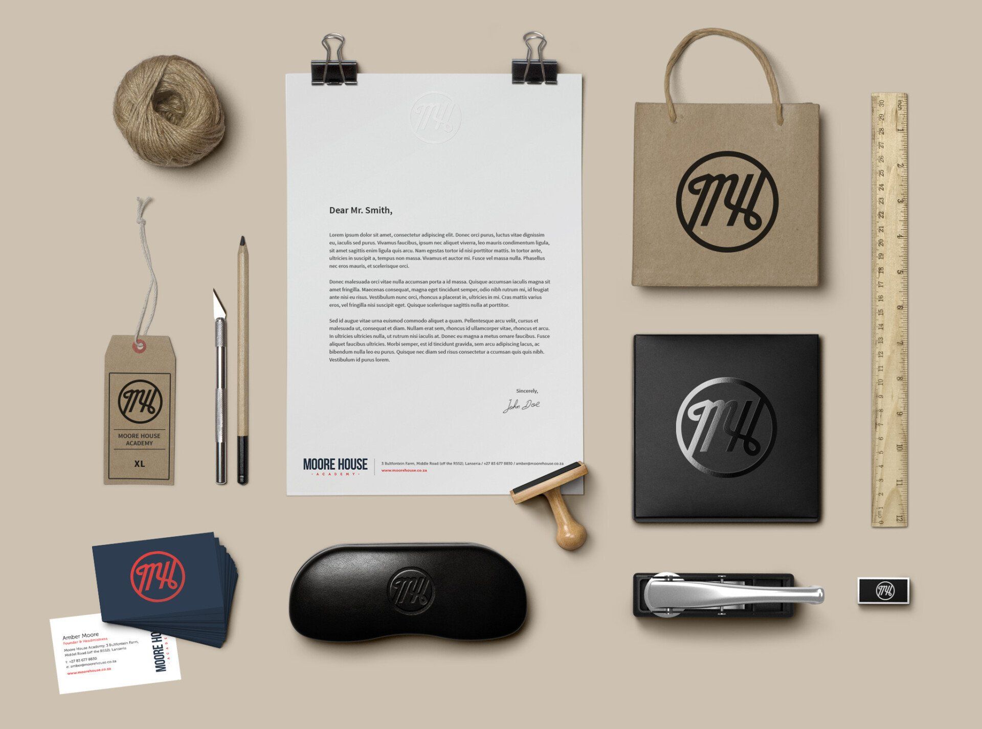A shot from above of various items of branded stationery designed for Moore House Academy by Visionar design agency.