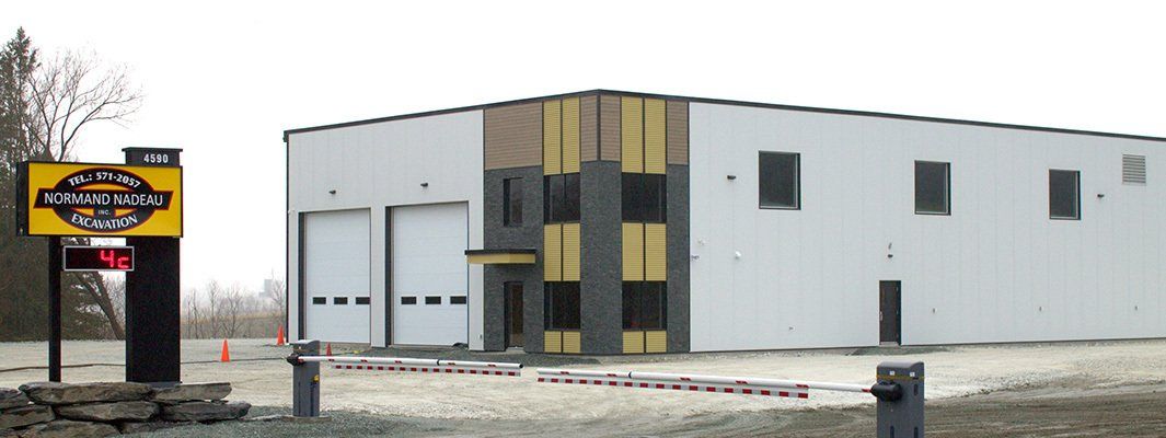 Panneau indiquant « Hunter's Lake CO » avec un bâtiment blanc aux fenêtres et portes de garage noires.