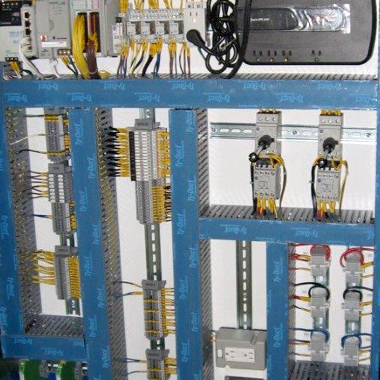 Panneau de commande électrique avec fils, bornes et dispositifs.