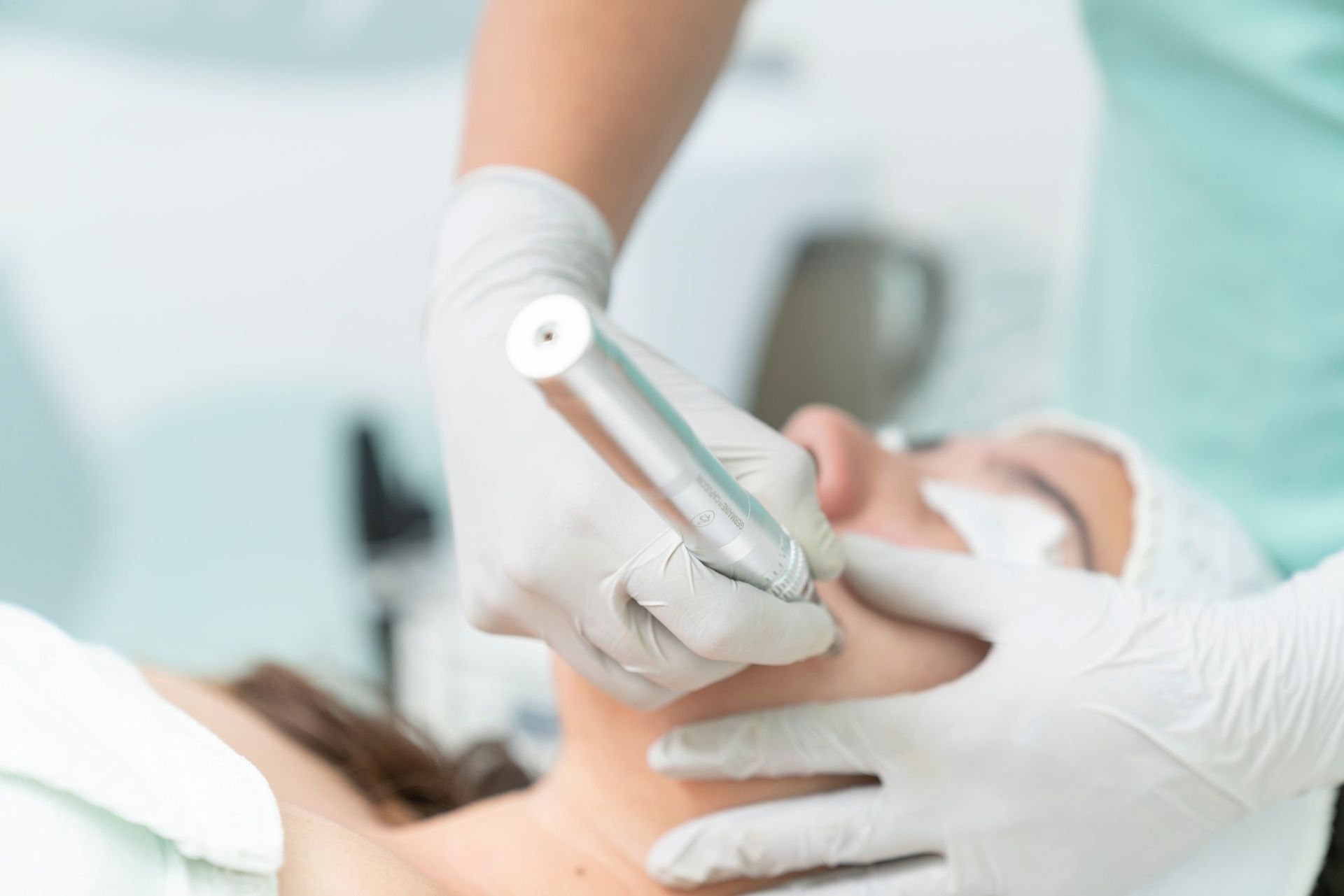 Dentist using a handheld tool on a patient's face during a clinical treatment