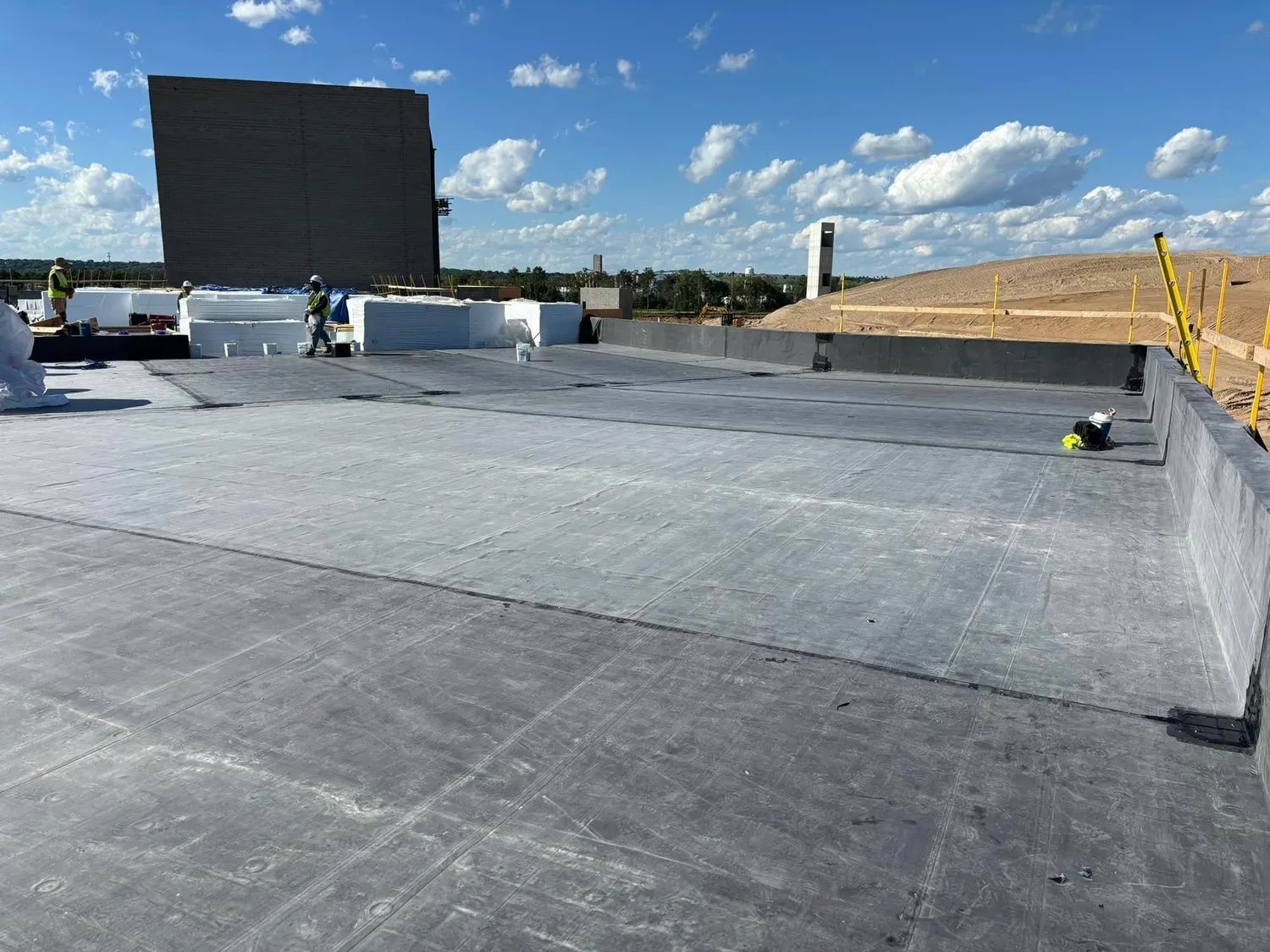 The roof of a building is being built and the workers are working on it.