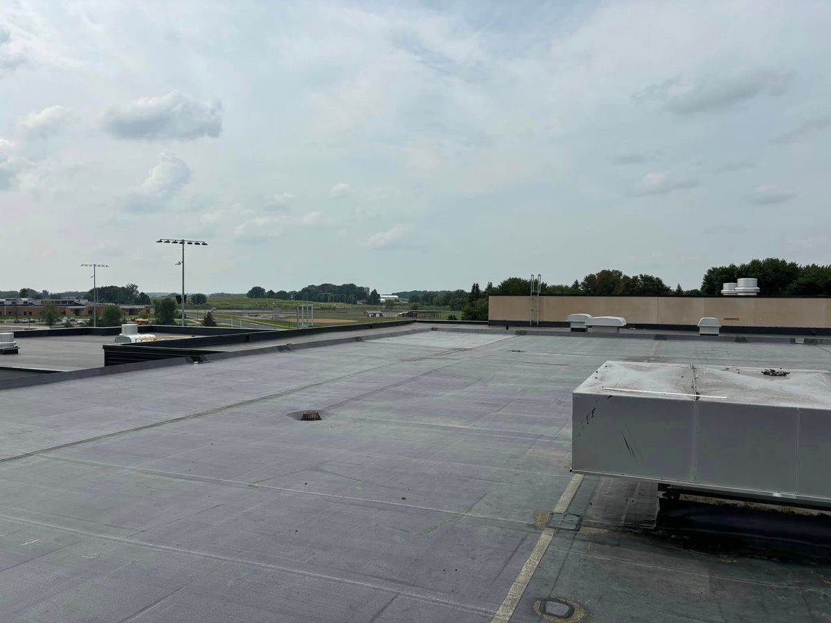 The roof of a building with a lot of clouds in the sky.