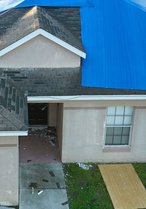 A house with a blue tarp on top of it