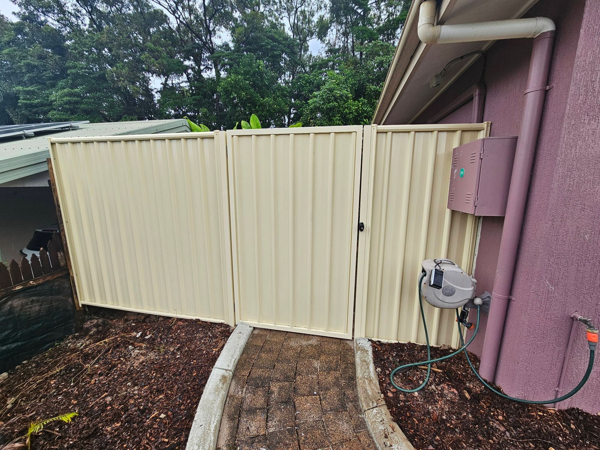 Beige Metal Gate Beside a House Exterior — KLS Fencing In Edmonton, QLD