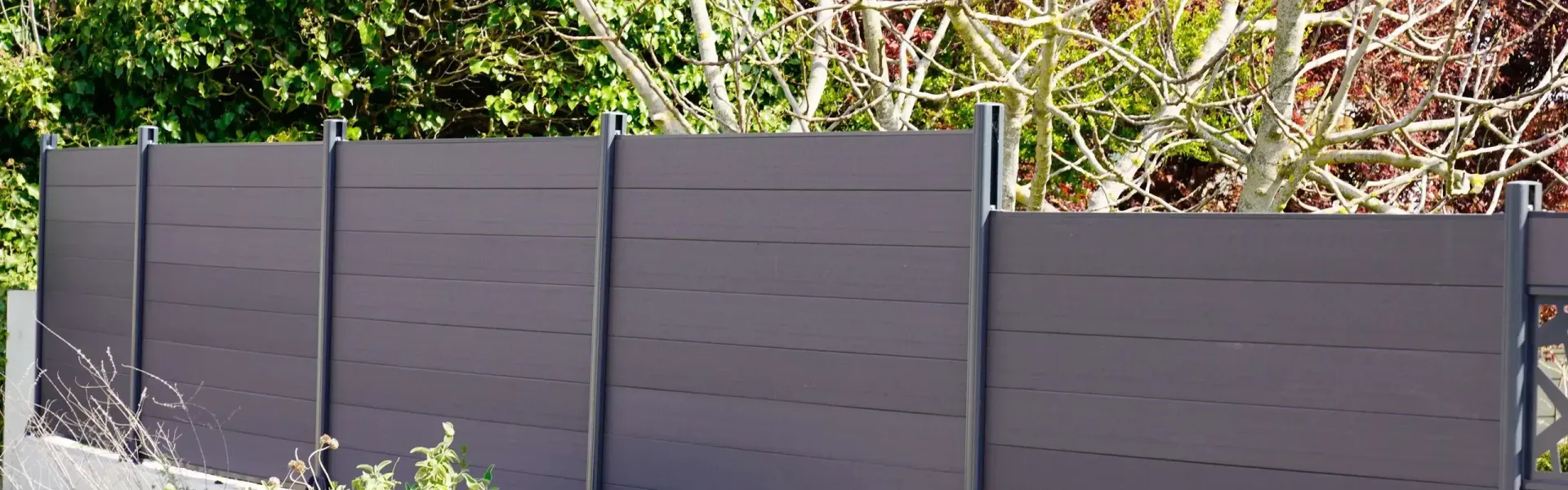 Dark Gray Fence Panels in a Leafy Outdoor Garden — KLS Fencing In Edmonton, QLD