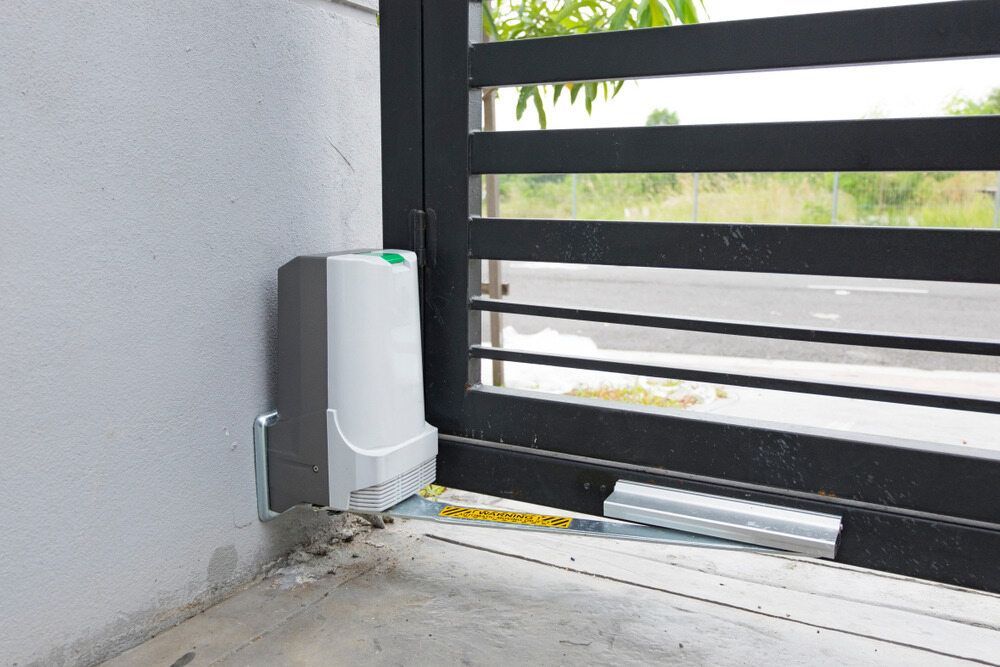 White Wall-mounted Device Beside a Black Gate — KLS Fencing In Mossman, QLD