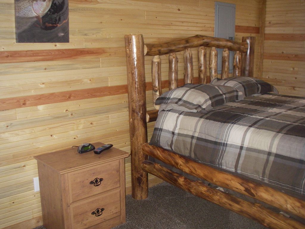 A bedroom with a log bed and a nightstand