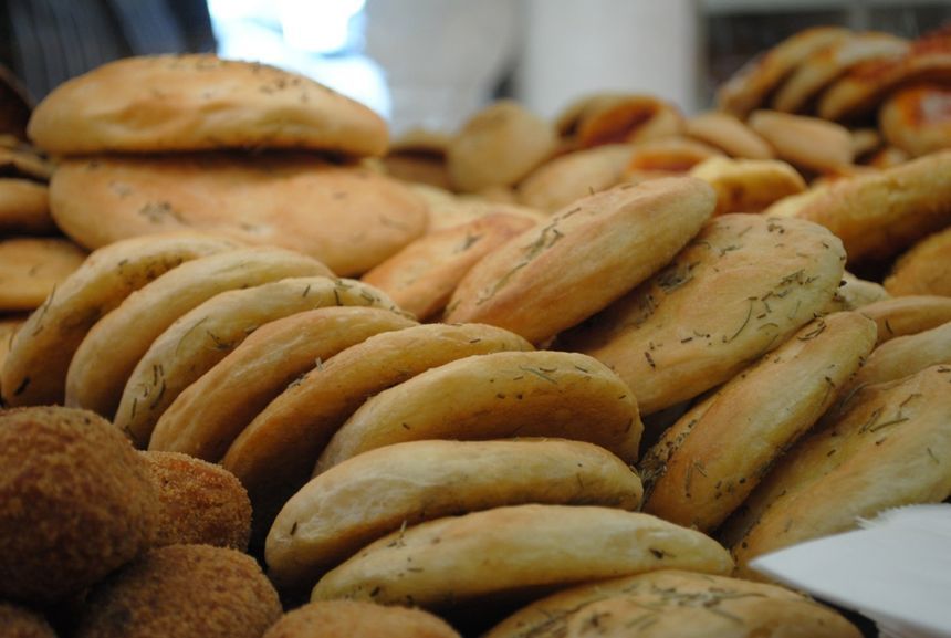 Assortimento di pagnotte e panini appena sfornati esposti in un panificio