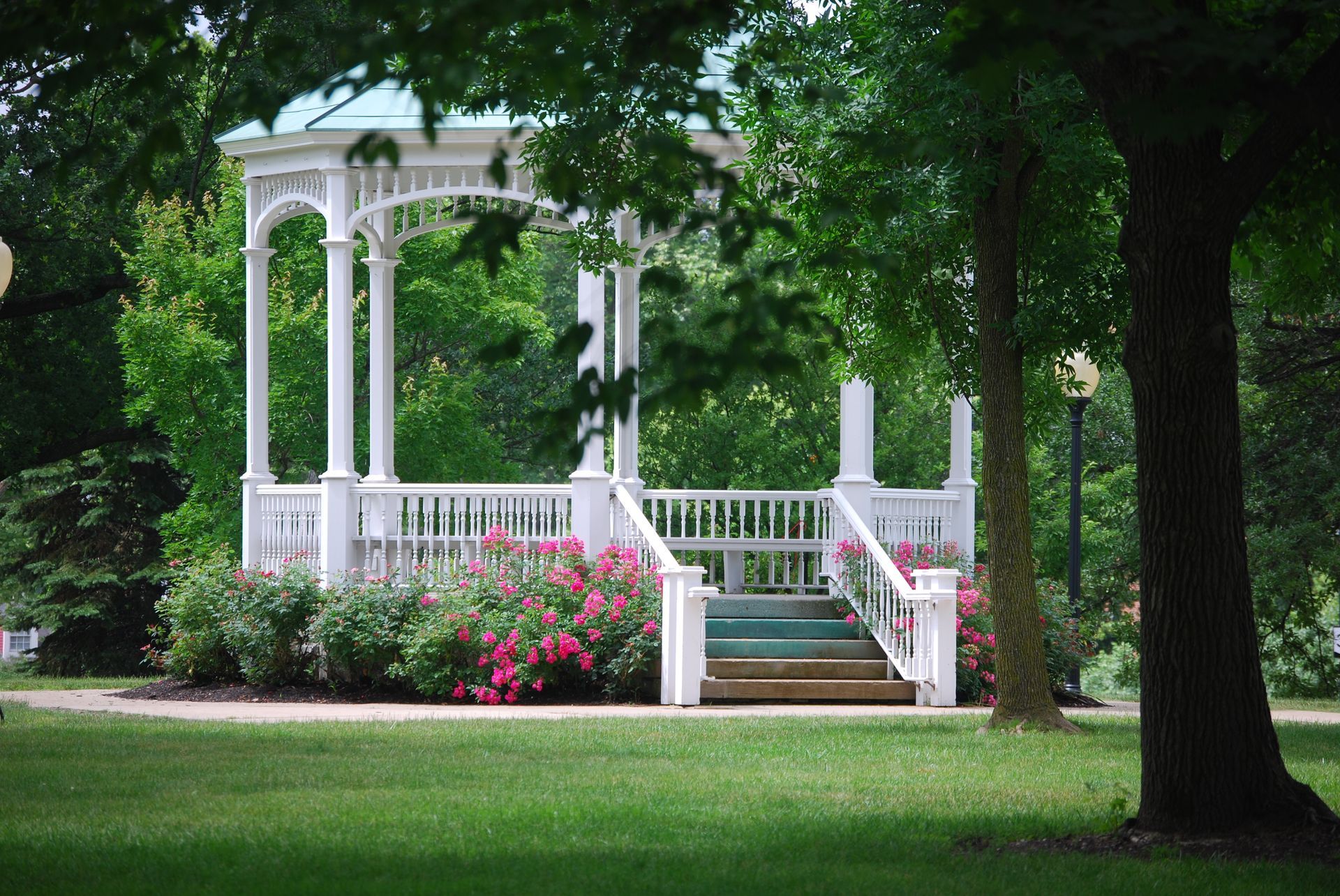 A gazebo in a park with stairs leading up to it