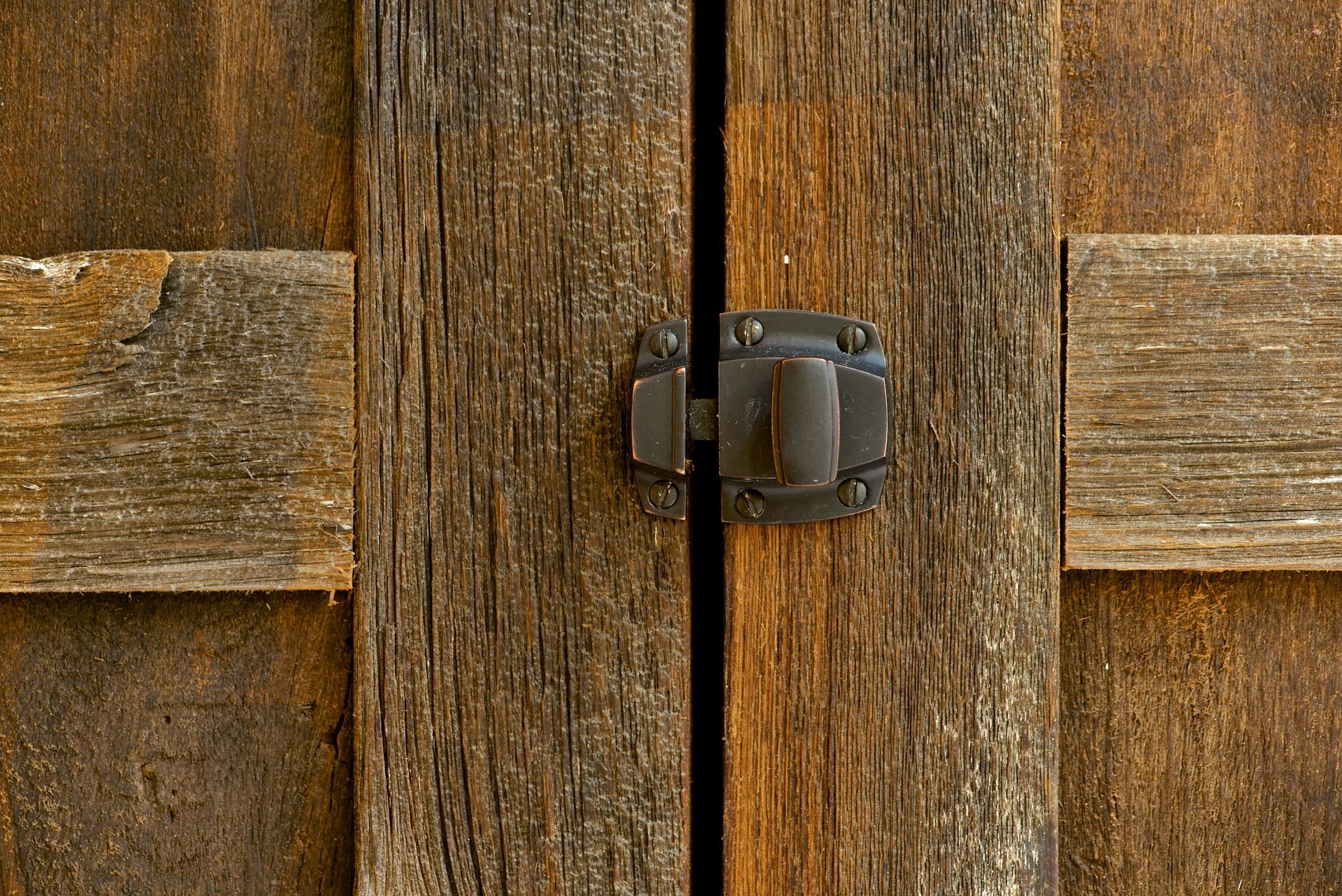Wooden cabinet doors closed with a dark metal latch.