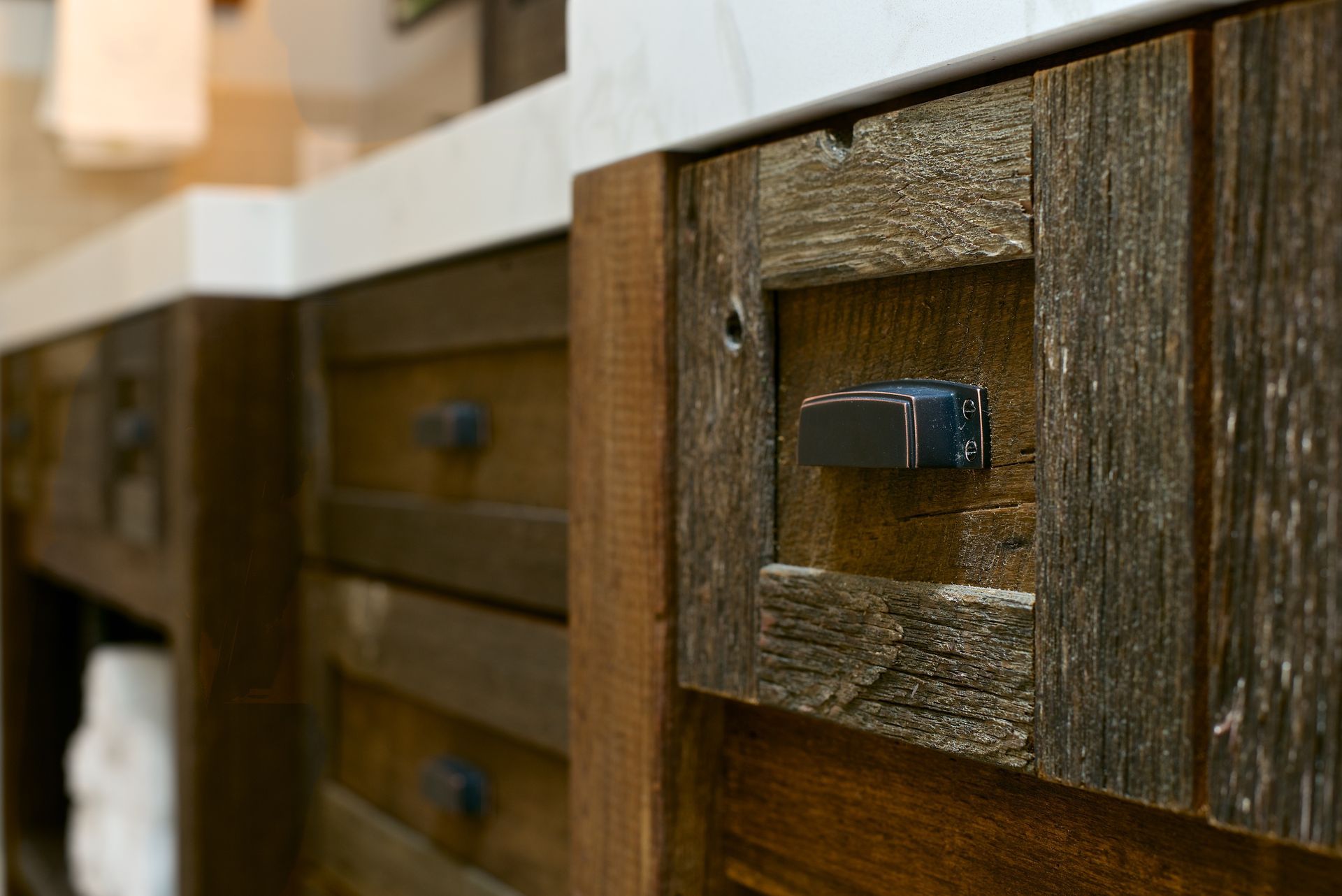 Rustic bathroom vanity with textured wood and metal hardware.