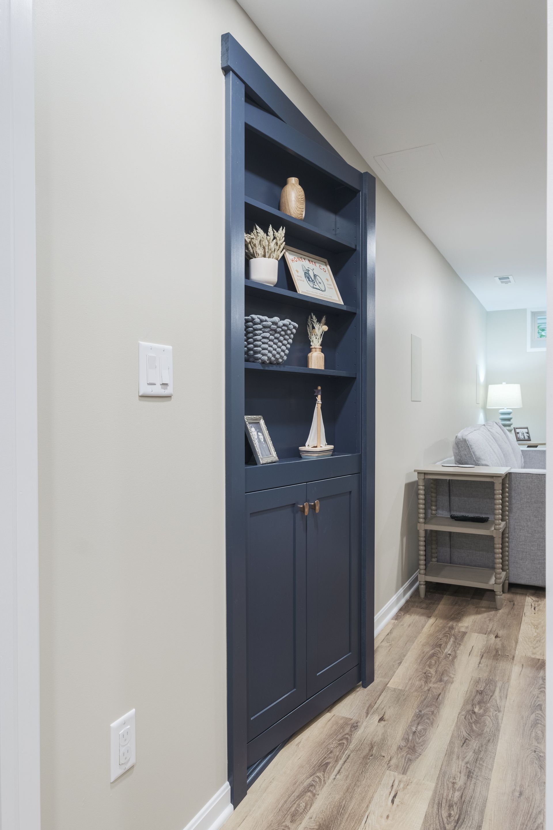 A hallway with a bookshelf built into the wall.