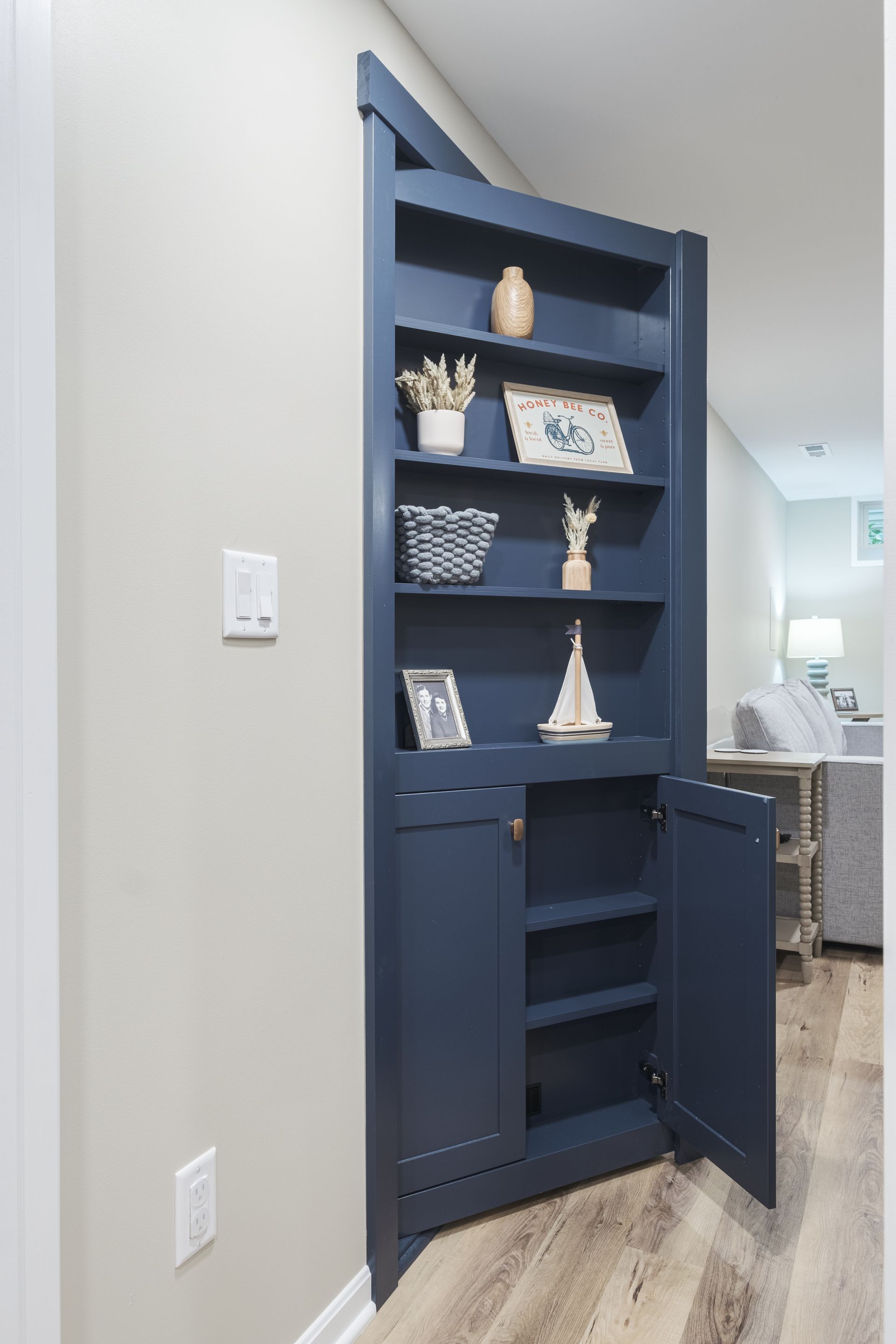 A blue bookcase with the doors open in a hallway