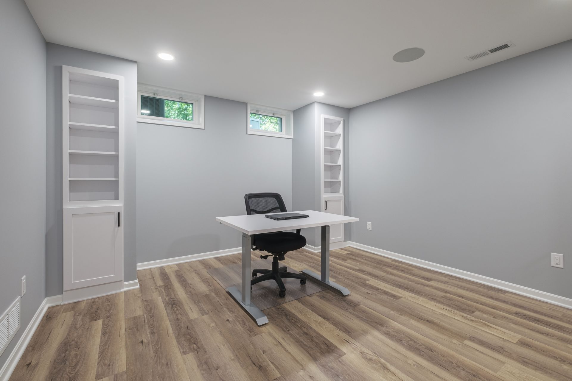 An empty room with a desk and chair in it.