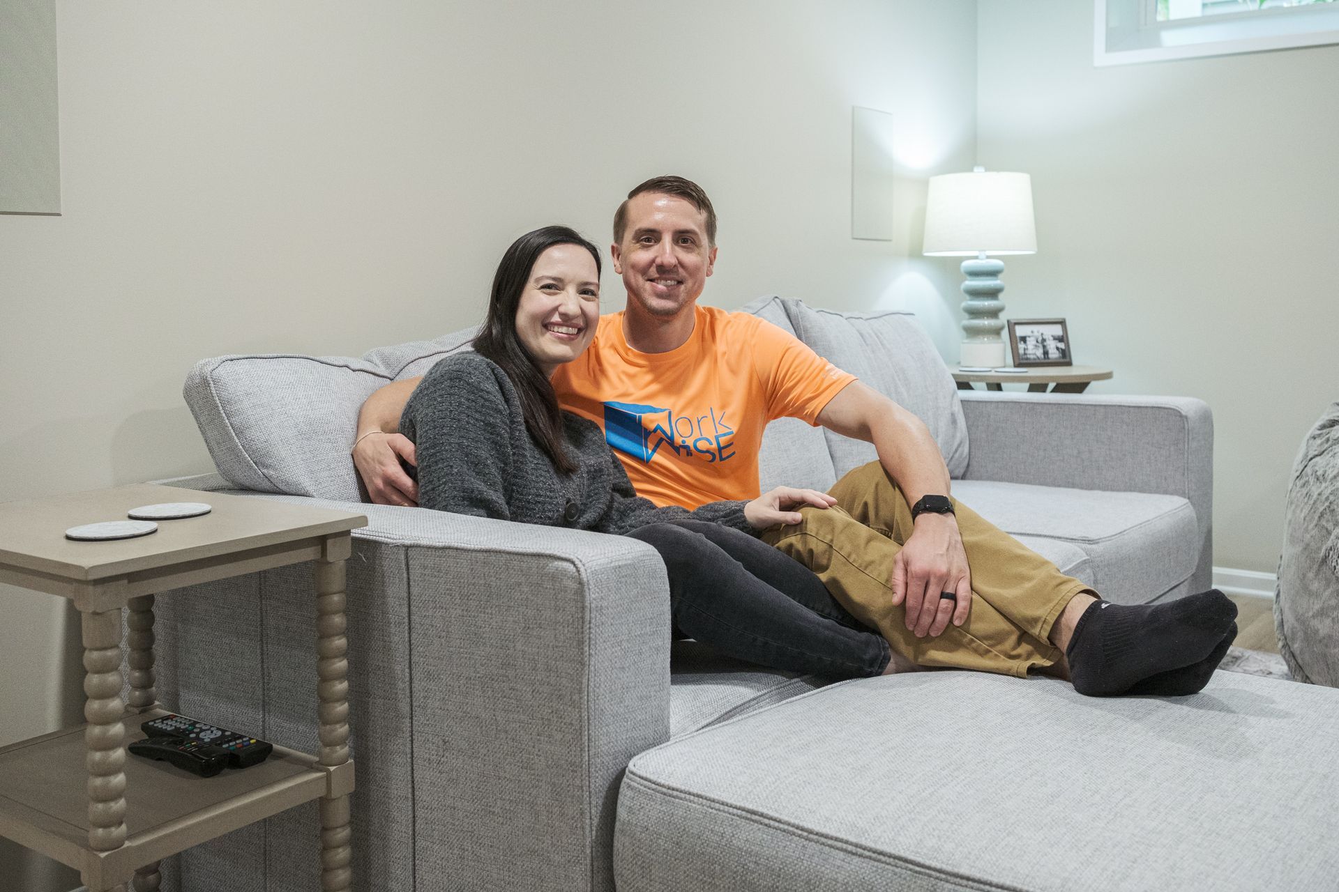 A man and a woman are sitting on a couch in a living room.