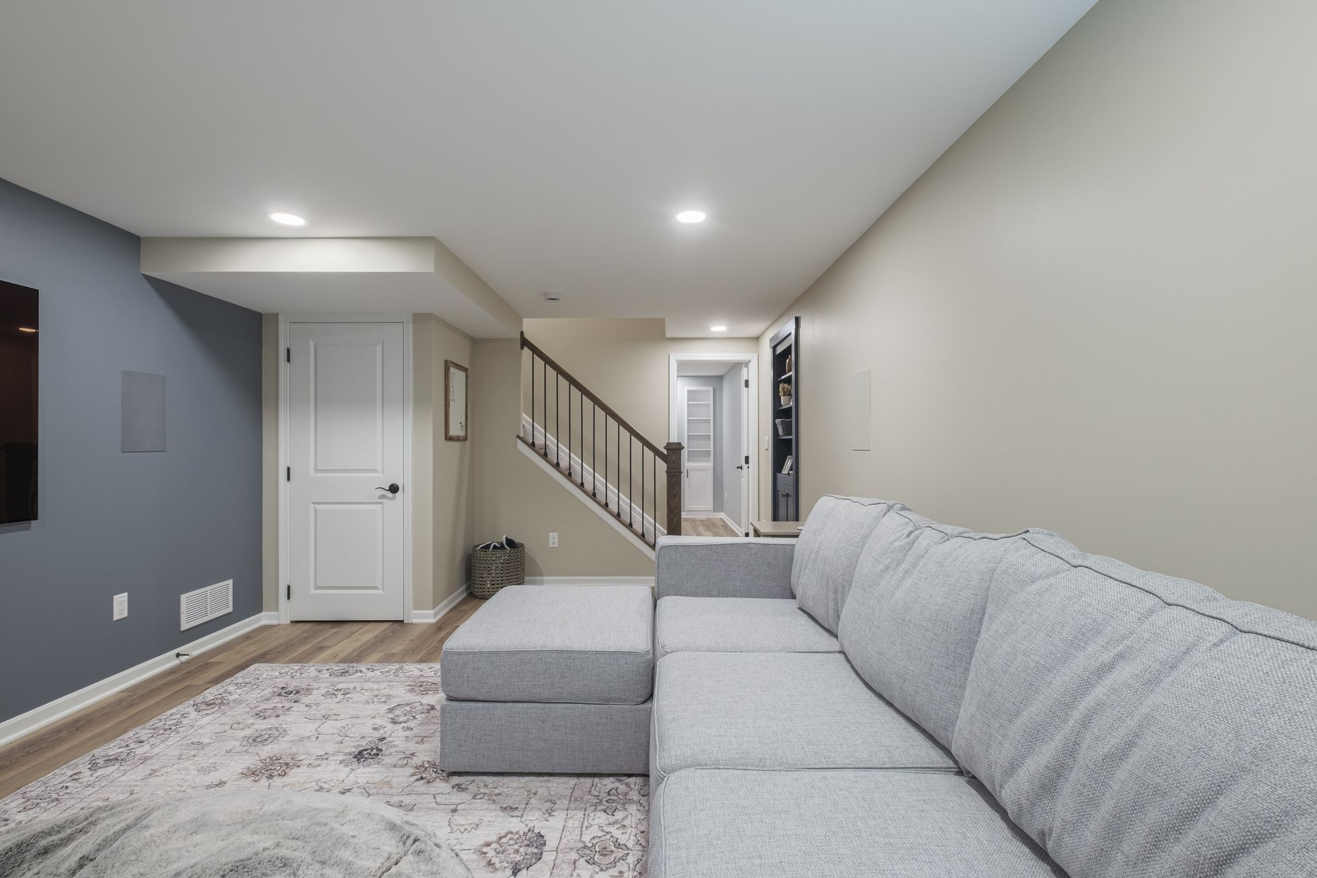 A living room with a couch and stairs in the background.