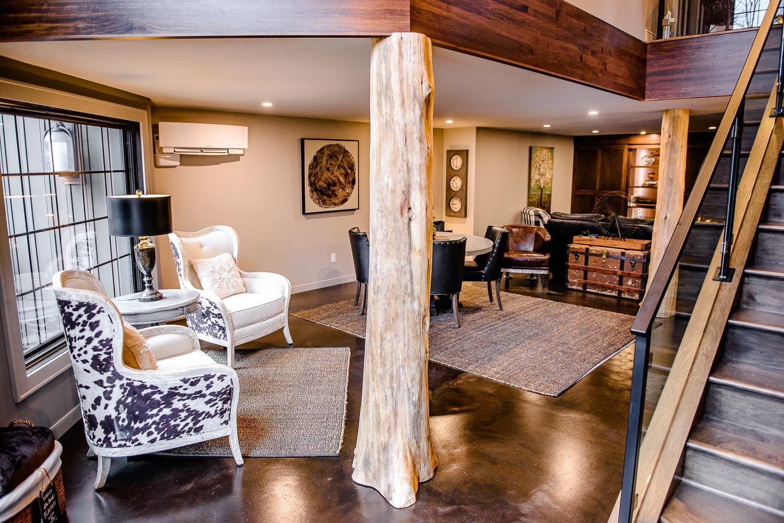 A living room with a staircase leading up to the second floor.