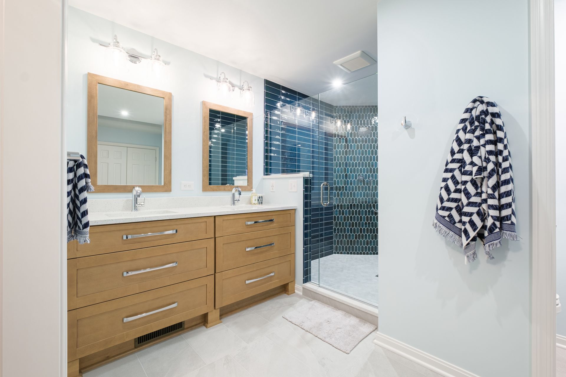 A bathroom with two sinks and a walk in shower.