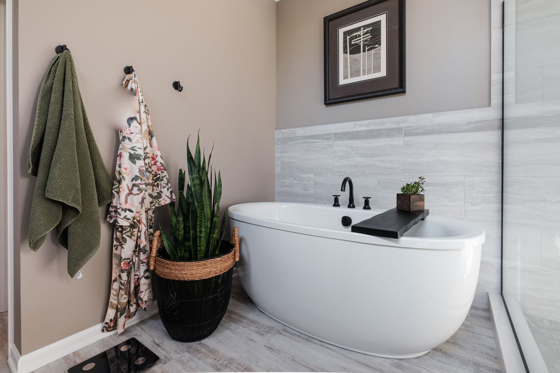 A bathroom with a bathtub and a potted plant.