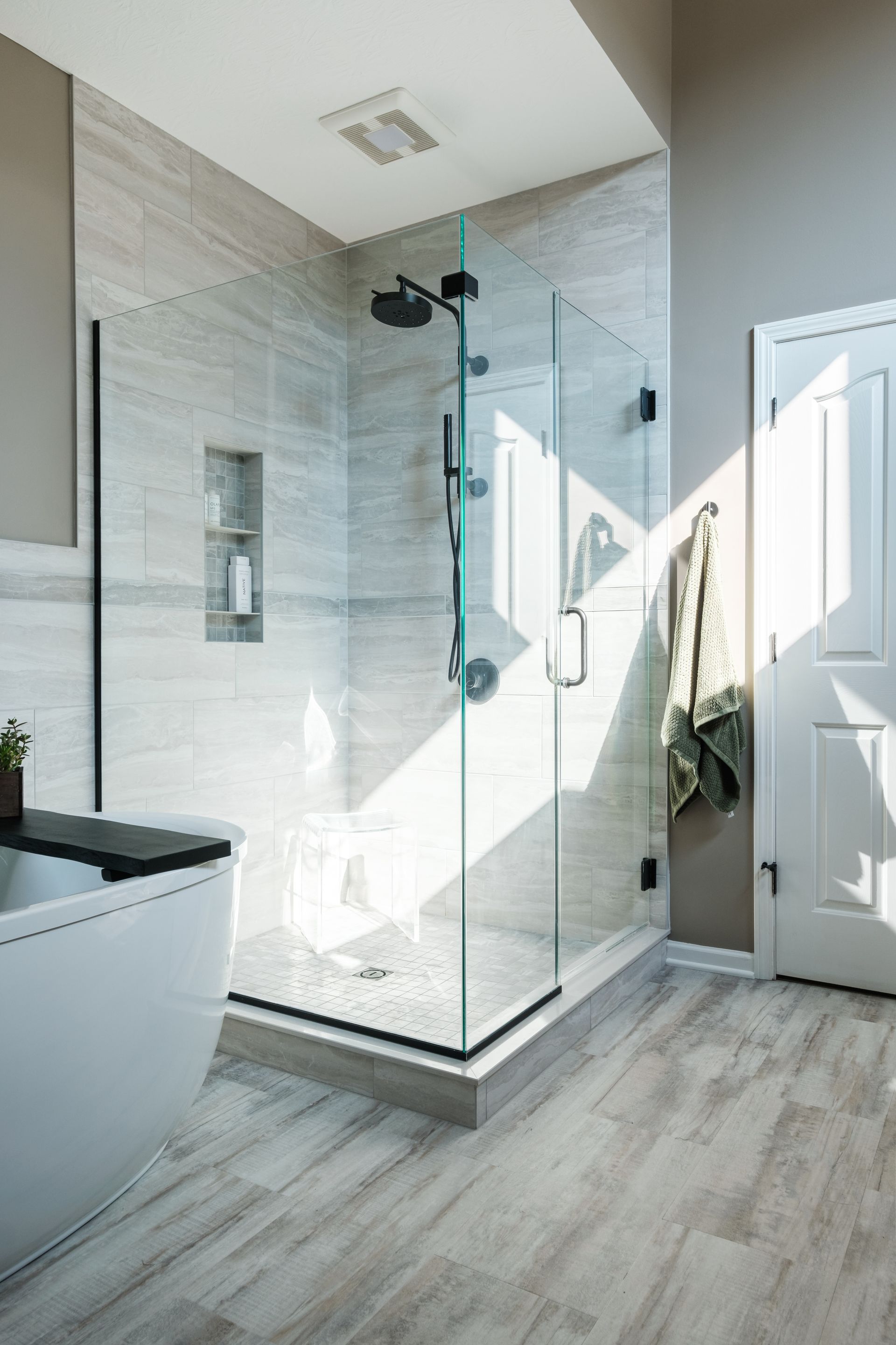 A bathroom with a walk in shower and a bathtub.