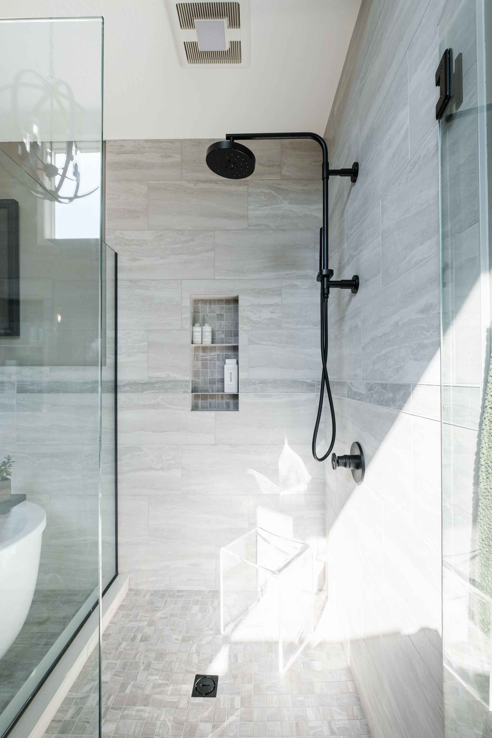 A bathroom with a walk in shower and a sink.