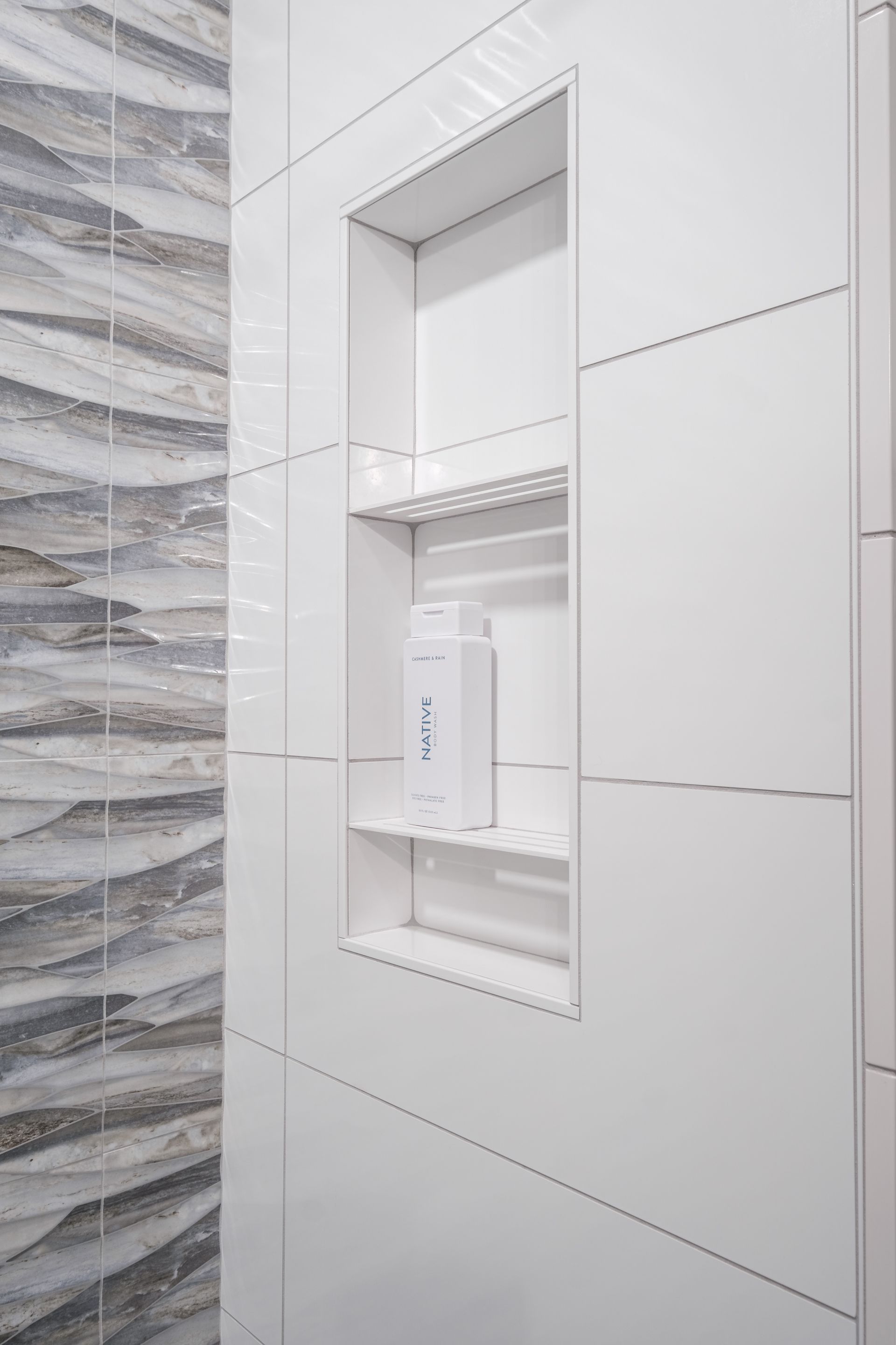 There is a soap dispenser in the shower niche.