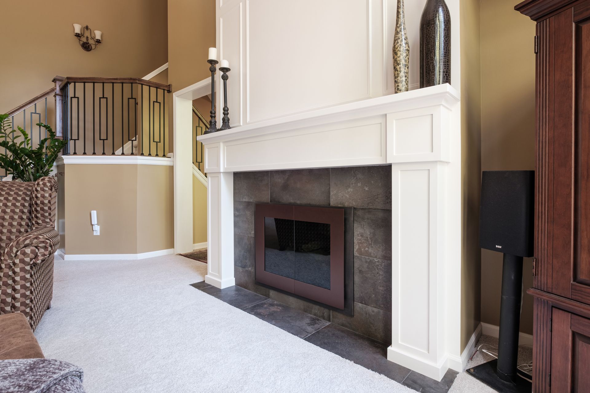 A living room with a fireplace and stairs in the background