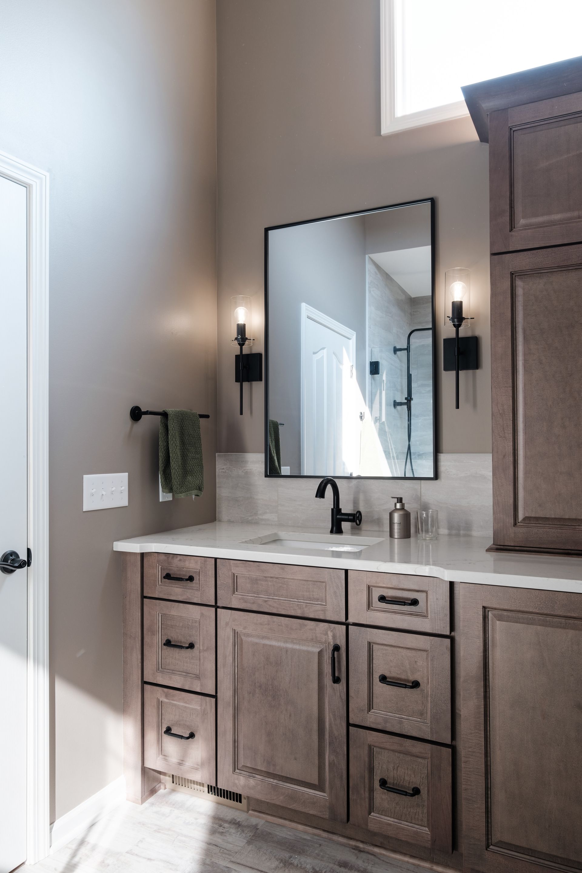 A bathroom with a sink , mirror and cabinets.
