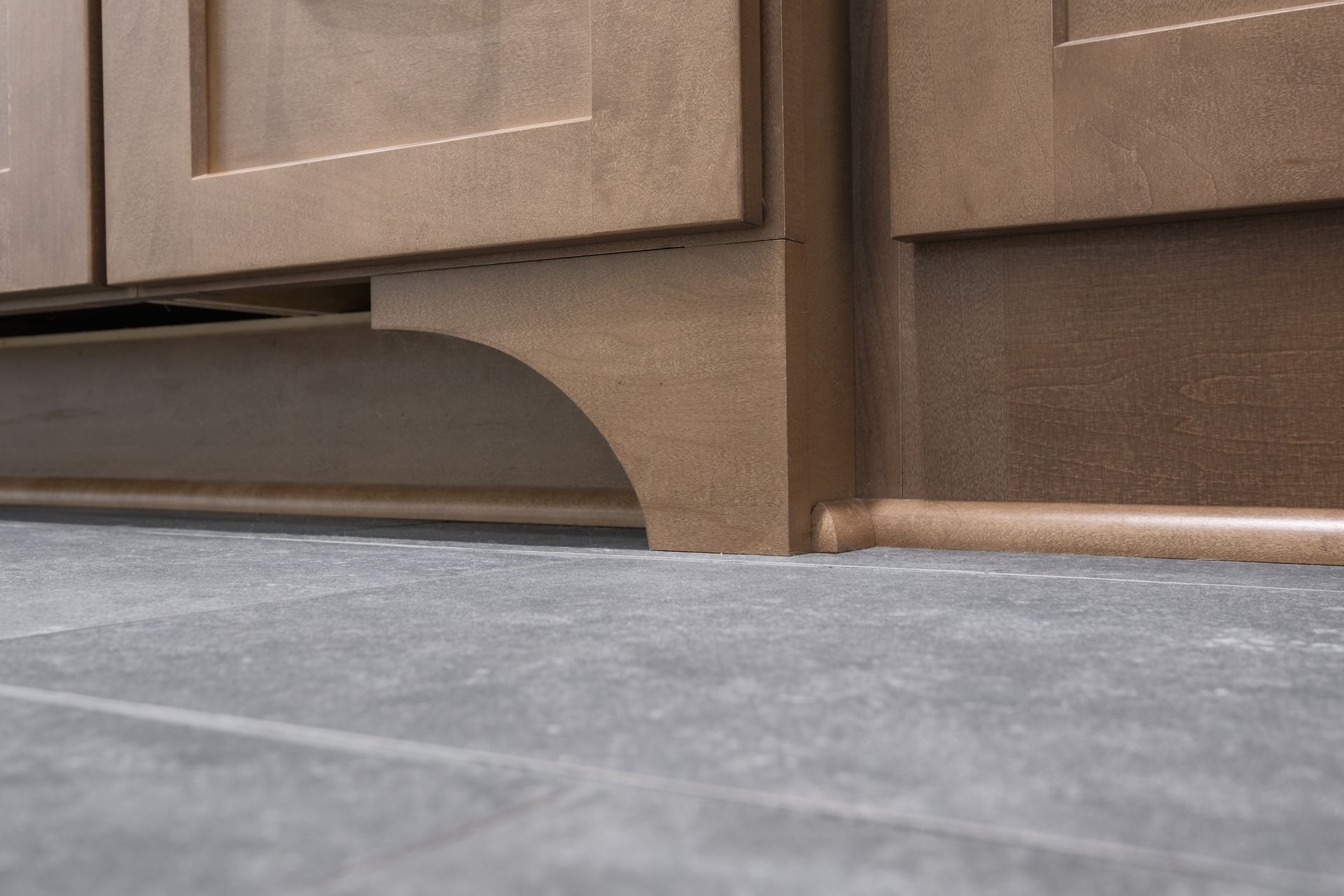 A close up of a cabinet with a tile floor underneath it