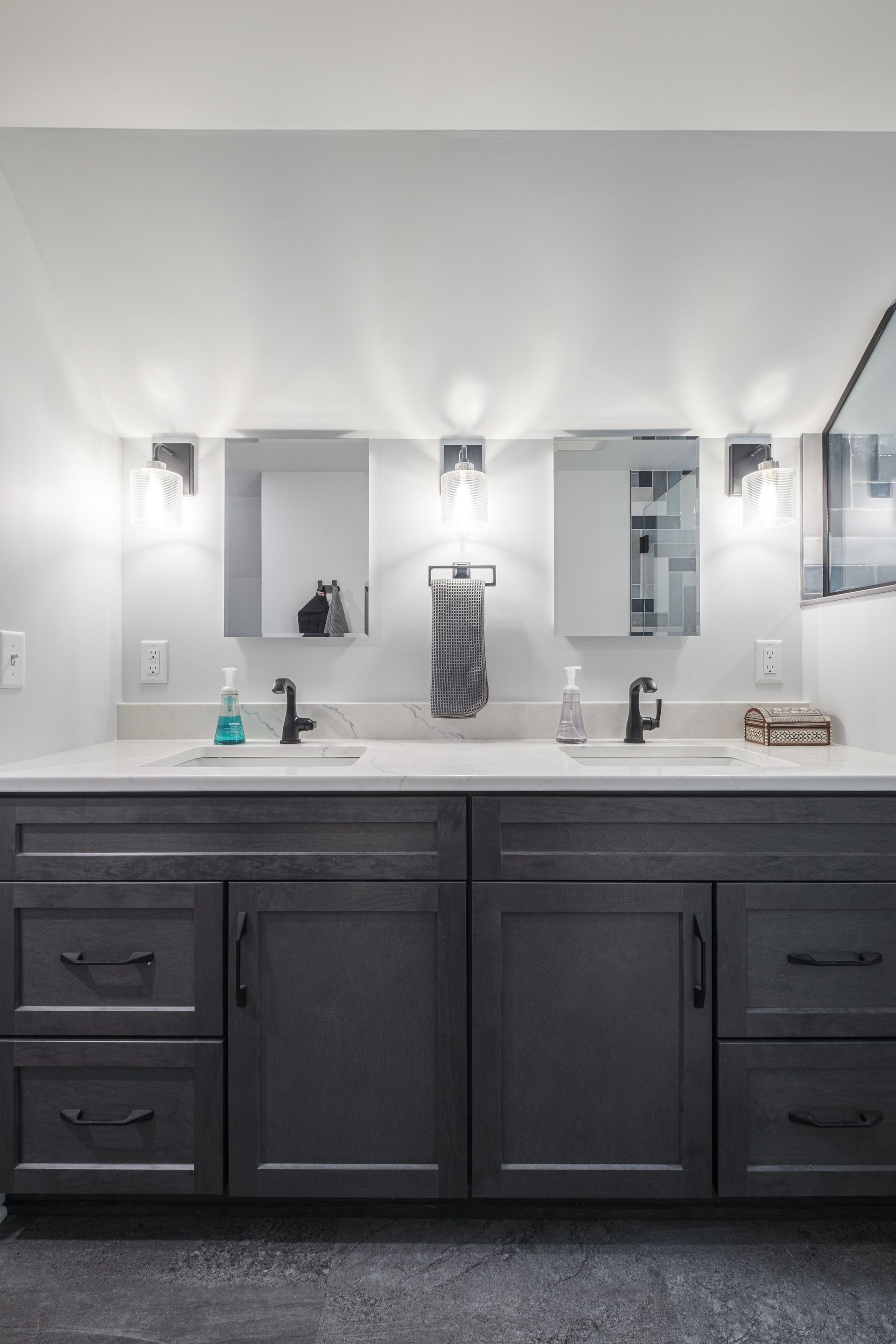 Gray double bathroom vanity with mirrors and sconces.