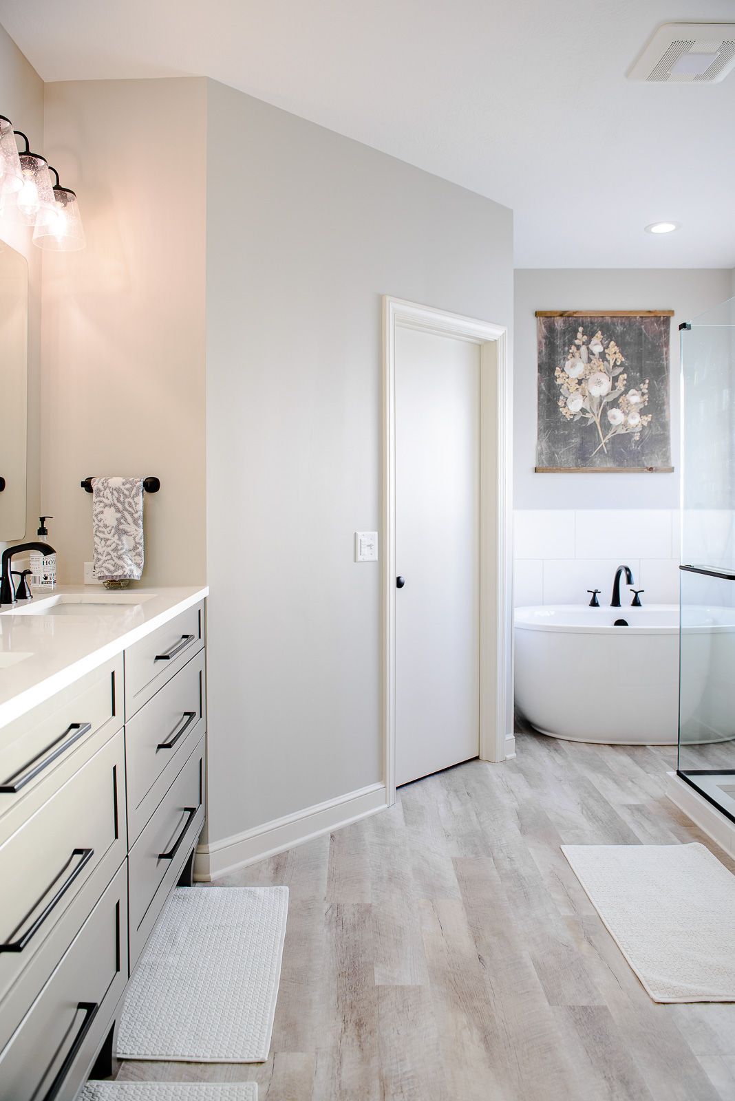 A bathroom with a tub , sink , and mirror.