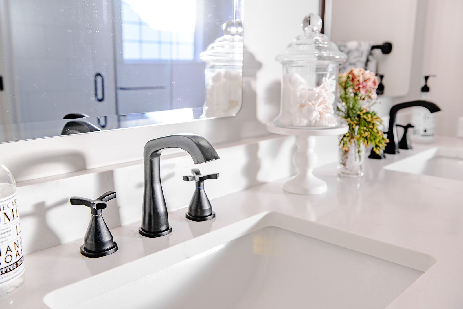 A bathroom sink with black faucets and a mirror.