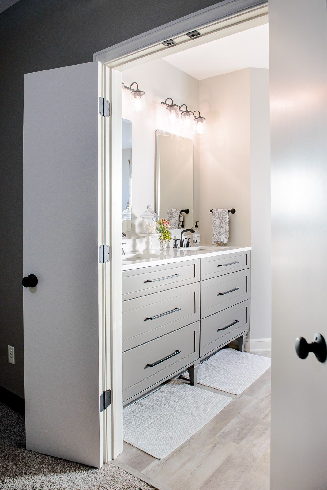 A bathroom with a sink , dresser , and mirror.