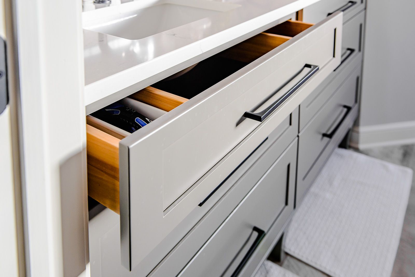 A bathroom vanity with drawers open and a sink.