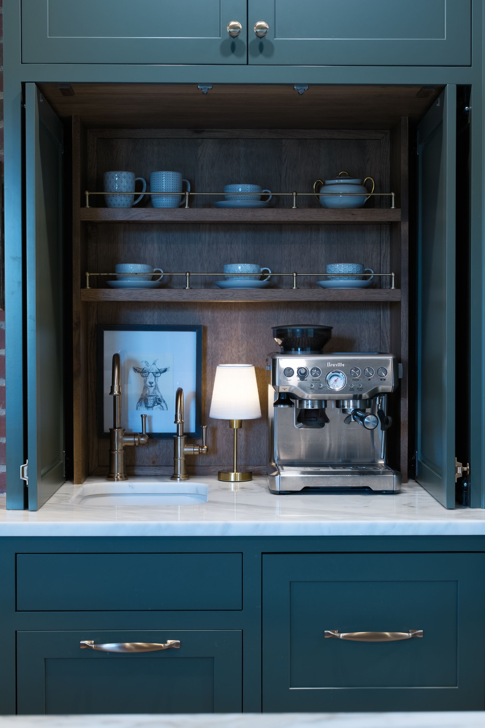 Built-in coffee station with shelves, espresso machine, sink, and teal cabinetry.